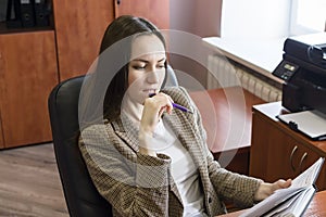 Portrait of young business women, thinking with pen and notepad in office