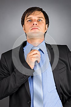 Portrait of a young businessman adjusting his neck tie getting r