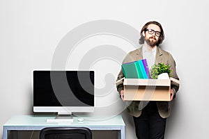 Portrait of a young businessman carrying box at his workplace. Fired from work