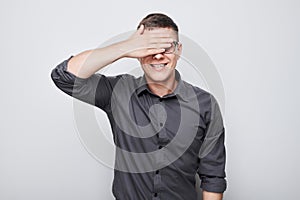 Portrait of young businessman covering eyes with hand isolated on white studio