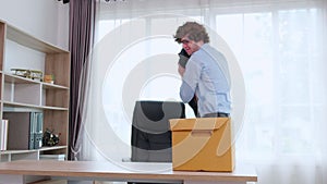 Portrait young businessman employee carrying cardboard box or belonging with frustrated and stress.