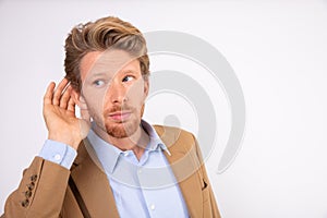 Portrait of young businessman listening to gossip