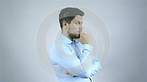 A portrait of a young businessman lost in thoughts over grey backgrounPortrait Of Thoughtful Young Man Isolated On Grey Background