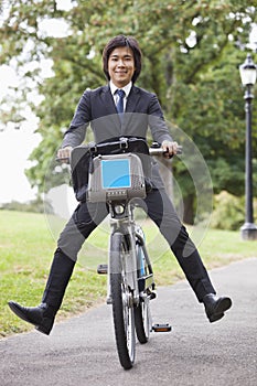 Portrait of young businessman riding bicycle with apart