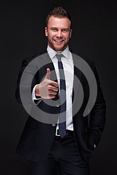 Portrait of young businessman showing thumbs up gesture