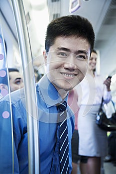 Portrait of young businessman sitting on the subway and looking at the camera