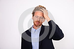 Portrait of young businessman slapping his forehead