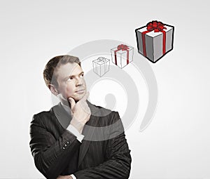 Portrait of young businessman thinking about gifts