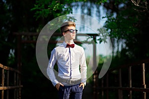 Portrait of a young businessman wearing a white shirt and sunglasses. Confident man makes plans