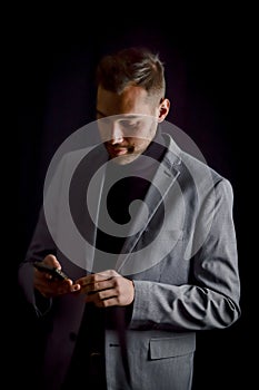 Portrait of a young businessman who is reading a message on his smartphone