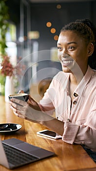 Portrait Of Young Businesswoman With Coffee Working On Laptop Sitting In Cafe Or Office