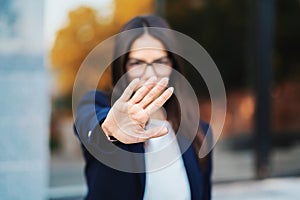 Portrait of young businesswoman disapproval gesture with hand: denial sign, no sign, negative gesture, professional