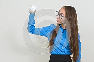 Portrait of young businesswoman with eyeglasses holding coffee cup upside down and looking surprised