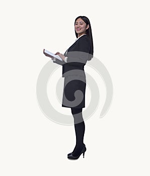 Portrait of young businesswoman holding a digital tablet, looking at camera, full length, studio shot