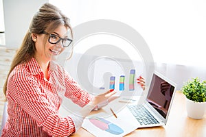 Portrait of young businesswoman showing diagrama of company`s growth photo