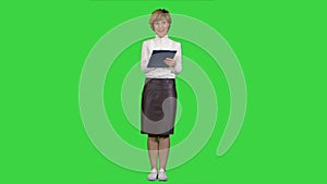 Portrait of young businesswoman with tablet asking questions on a Green Screen, Chroma Key