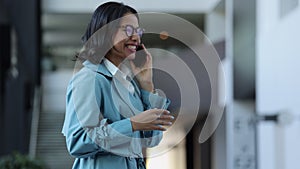 Portrait of young businesswoman talking on phone and laughing, walking in airport interior spbi.