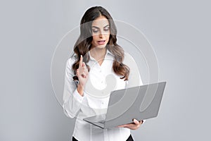 Portrait of young businesswoman using laptop computer isolated on gray background. Business women in shirt excited