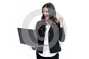 Portrait of young businesswoman using laptop computer isolated on gray background. Business women in suit excited