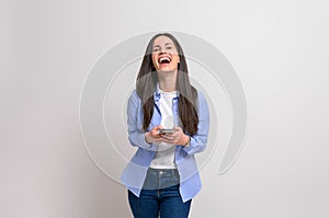 Portrait of young businesswoman using smart phone and laughing ecstatically over white background