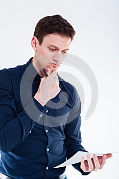 Portrait of young businsessman holding a pen and a sheet of paper