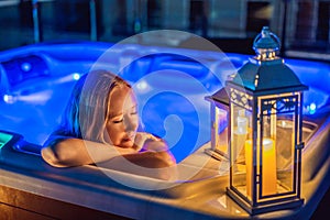 Portrait of young carefree happy smiling woman relaxing at hot tub at night during enjoying happy traveling moment