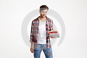 Portrait of a young casual male student holding books