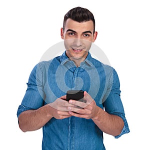 Portrait of young casual man texting on the phone