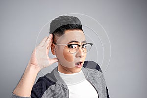 Portrait of young casual man which overhears conversation over white background