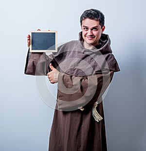 Portrait of Young catholic monk with board