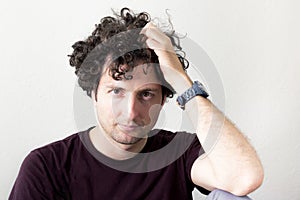 Portrait of a young, Caucasian, brunet, curly haired man looking
