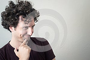 Portrait of a young, Caucasian, brunet, curly haired man with mo