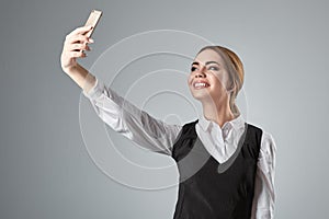 Portrait of young caucasian business woman in suit doing selfie on the phone.