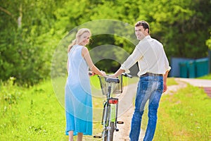 Portrait of Young Caucasian Couple Leading One Bicycle Together