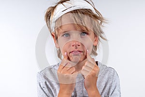 Portrait young caucasian cute boy blond hair with trauma injury and bandage head. Isolated on white background. Sick sad