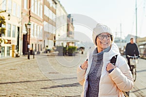 Portrait of a young Caucasian European woman tourist in glasses for the view of a white hat and a down jacket with a black