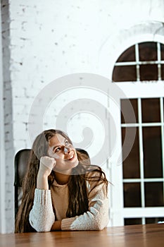 Portrait of young caucasian girl in casual clothes looks dreamful and happy