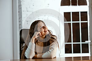 Portrait of young caucasian girl in casual clothes looks dreamful and happy