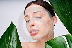 Portrait of a young Caucasian girl in green tropical leaves