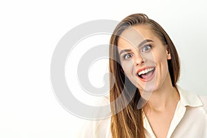 Portrait of a young caucasian happy woman wearing white shirt smiling with open mouth against the white background.