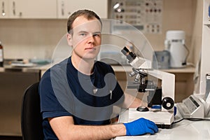 Portrait of young caucasian male scientist, medical worker, tech or graduate student works in modern biological laboratory