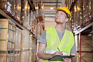 Portrait of young caucasian man checking stock and looking at goods working in a warehouse.