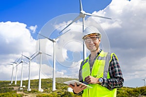 Young worker looking and checking wind turbines at field
