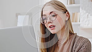 Portrait of young caucasian woman blonde millennial girl in glasses student freelancer client looking at laptop screen