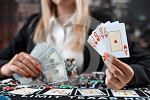 portrait of young caucasian woman with cards and chips playing poker at casino