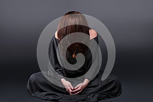 Portrait of a young caucasian woman praying. Prayer girl dressed in Vestments of a nun on gray studio background