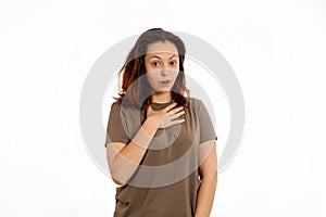 Portrait of a young Caucasian woman in surprise, putting her hand on her chest. White background. The concept of surprise