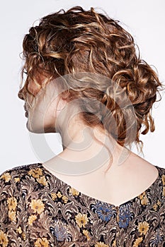 Portrait of a young caucasian woman with wavy hair  in vintage retro dress from back side