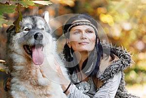 Portrait of a young charming woman with an Alaskan Malamute dog in the autumn forest