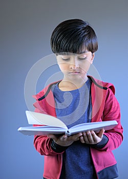 Portrait of young child reading book